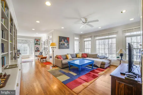 a living room with furniture a large window and wooden floor