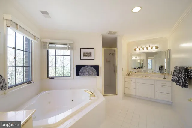 a spacious bathroom with a bathtub a double vanity and a sink