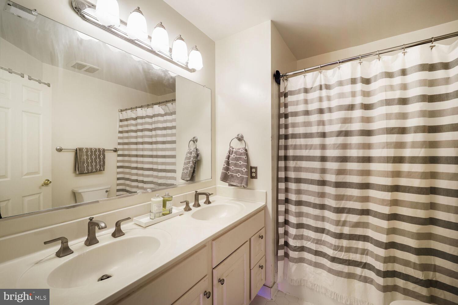 5119 Warren Place Northwest Washington, DC 20016 - Photo 27 of 37 a bathroom with a sink a double vanity and a mirror