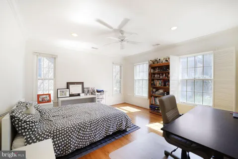 a bedroom with a bed a table and a large window