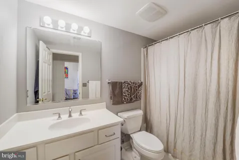 a bathroom with a toilet a sink and a mirror