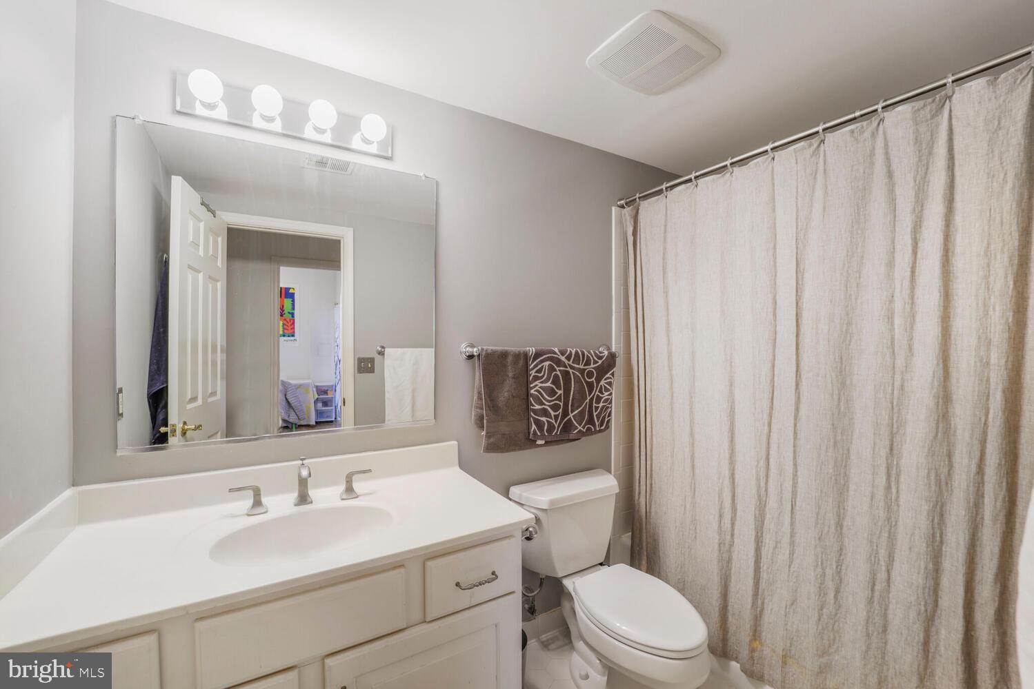 5119 Warren Place Northwest Washington, DC 20016 - Photo 33 of 37 a bathroom with a toilet a sink and a mirror
