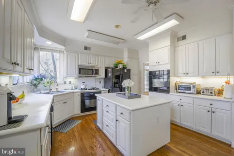 a kitchen with white cabinets and white appliances