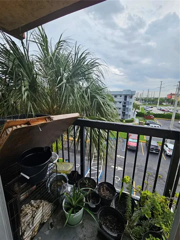 a view of a balcony with chairs and potted plants