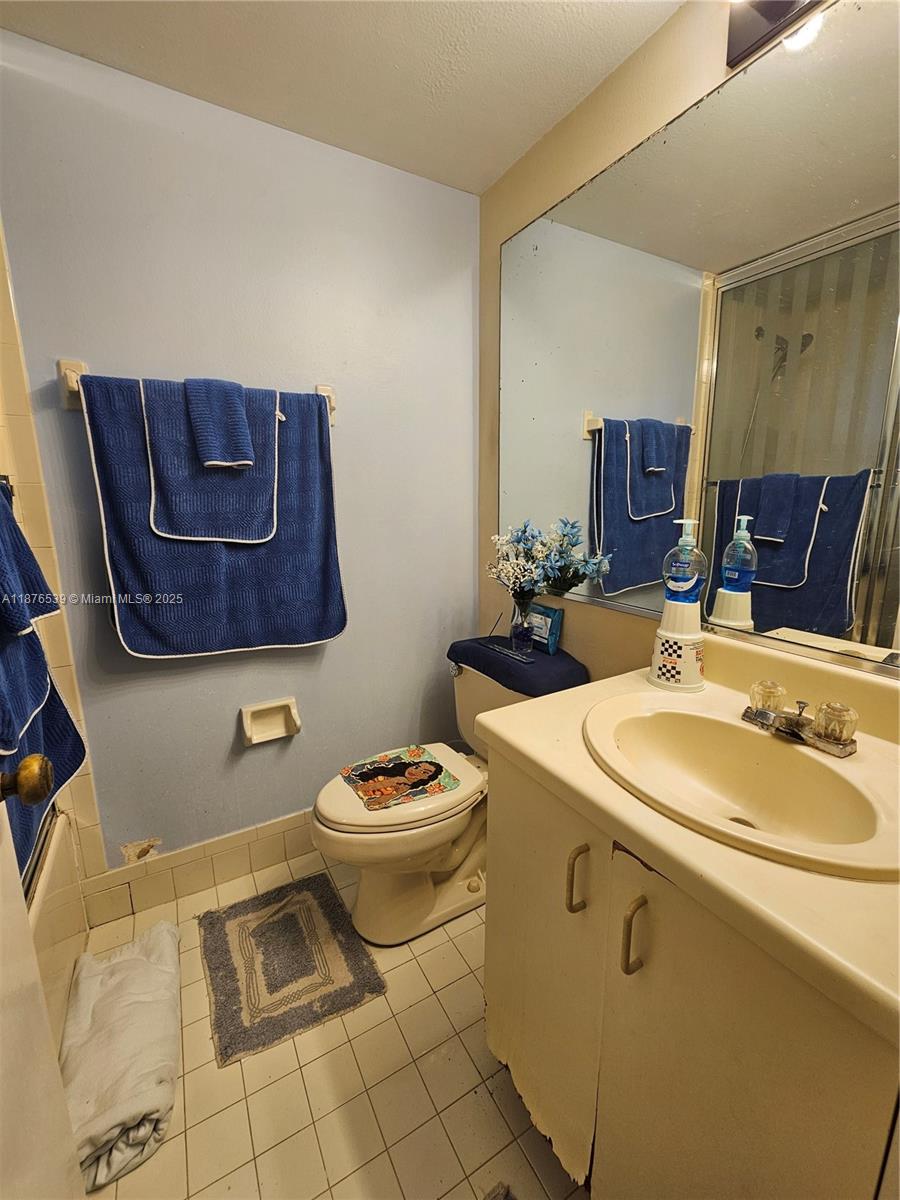 5350 West 21st Court, Unit 407 Hialeah, FL 33016 - Photo 9 of 15 a bathroom with a toilet sink and mirror