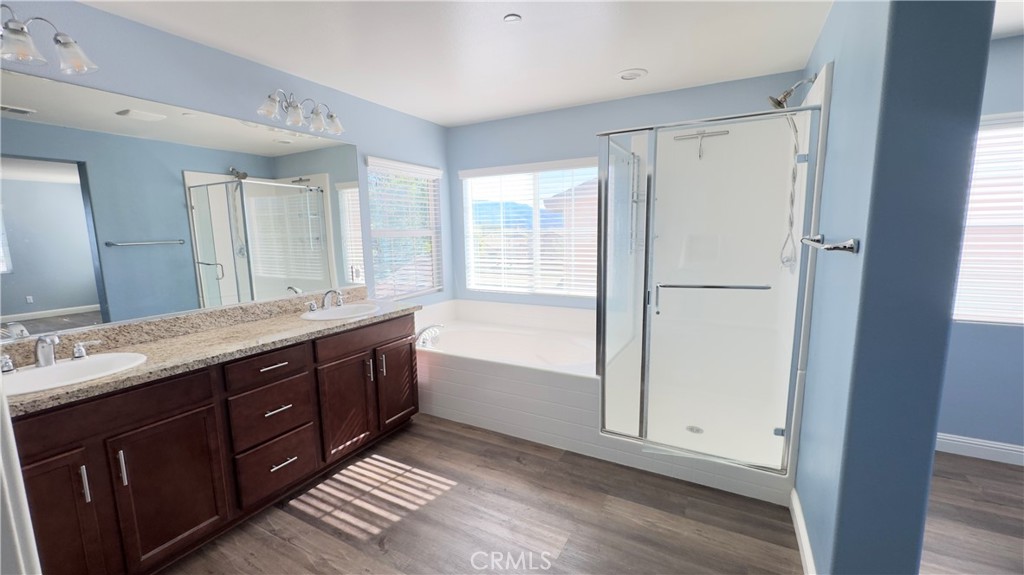 3687 White Ash Road San Bernardino, CA 92407 - Photo 22 of 29 a bathroom with a double vanity sink a mirror and a bathtub