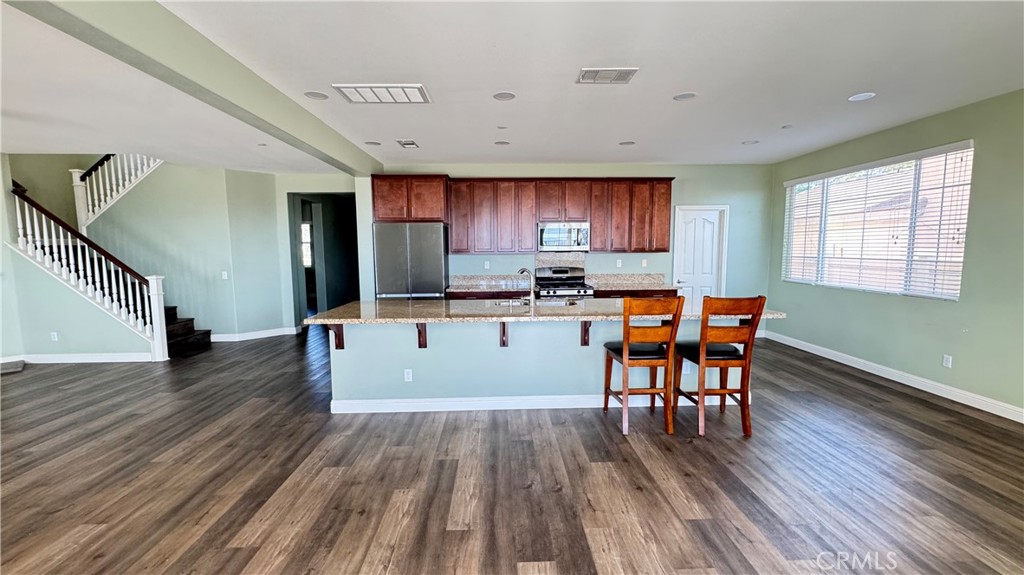 3687 White Ash Road San Bernardino, CA 92407 - Photo 8 of 29 a kitchen with stainless steel appliances wooden floors and wooden cabinets