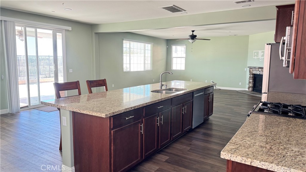3687 White Ash Road San Bernardino, CA 92407 - Photo 10 of 29 a kitchen with a granite countertop sink and a wooden cabinets