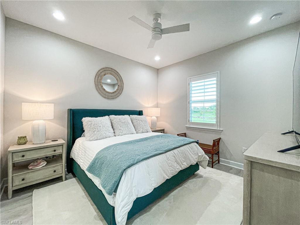 7162 Saona Court Naples, FL 34113 - Photo 13 of 19 a bedroom with a bed and a table in it