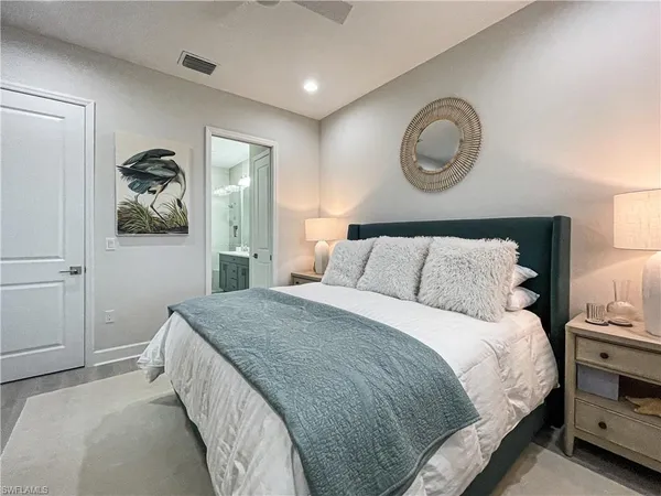 a bedroom with a bed and painting on the wall