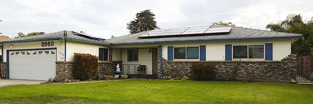 a view of a house with a yard and pathway