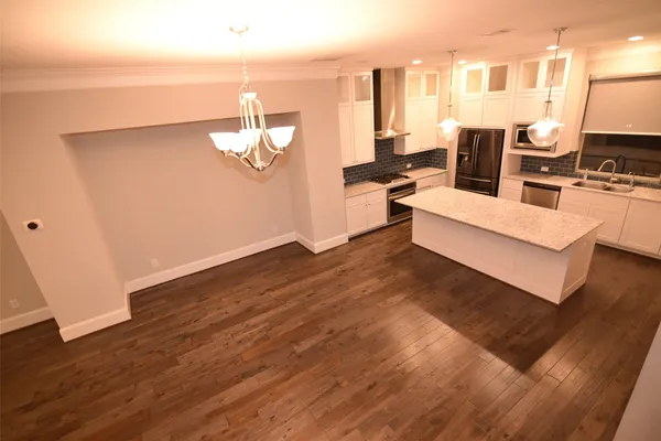 a living room with couches chairs and kitchen view with wooden floor