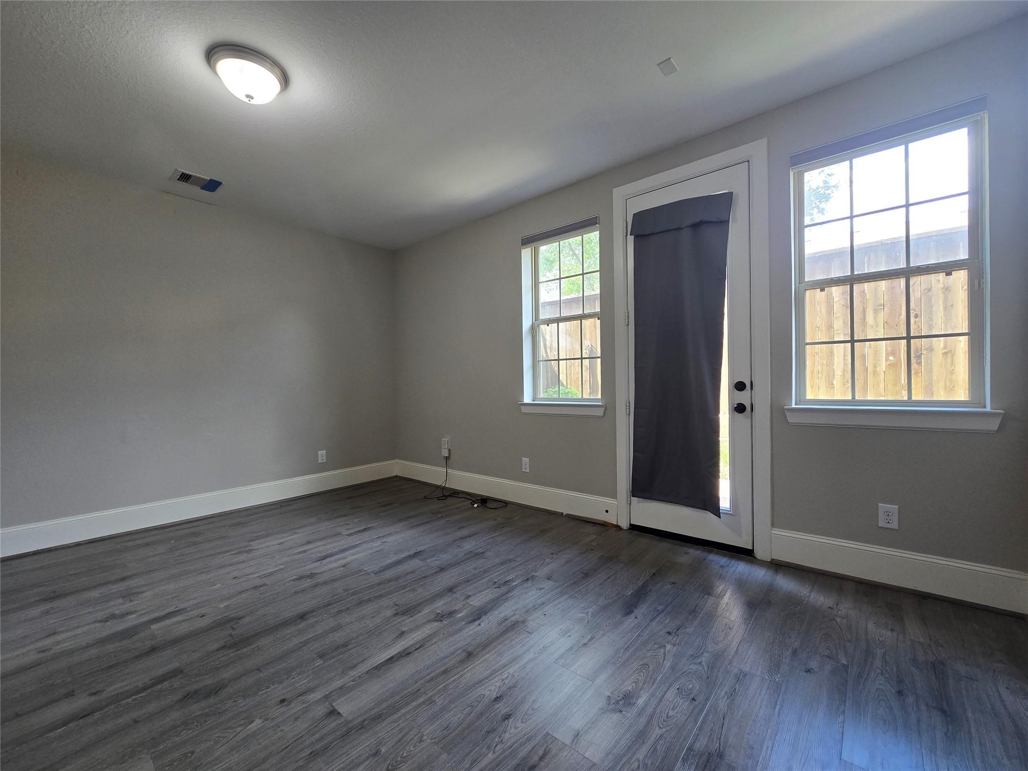 11918 Stirling Row Lane Houston, TX 77082 - Photo 3 of 21 an empty room with wooden floor and windows