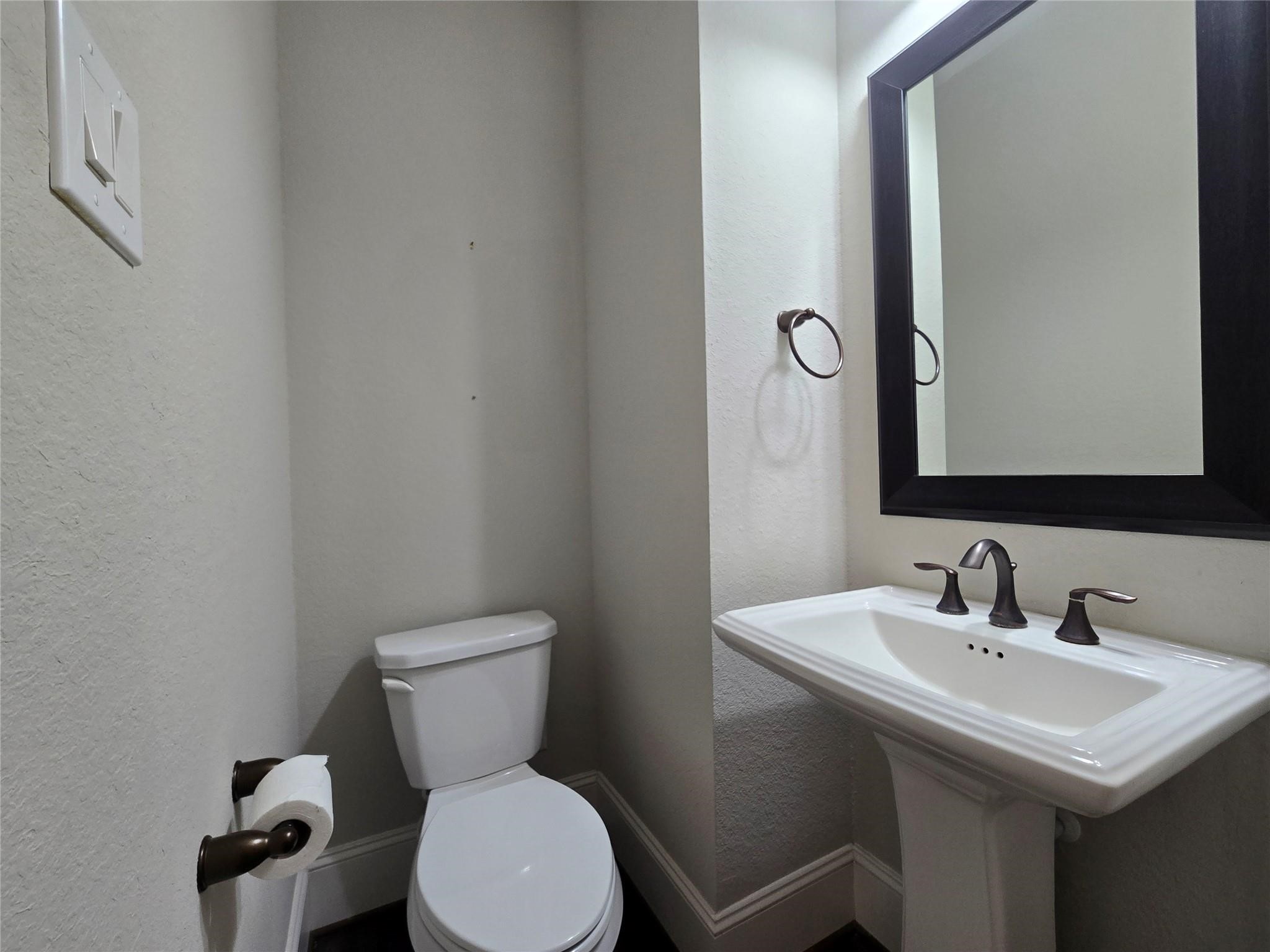 11918 Stirling Row Lane Houston, TX 77082 - Photo 4 of 21 a bathroom with a toilet a sink and mirror