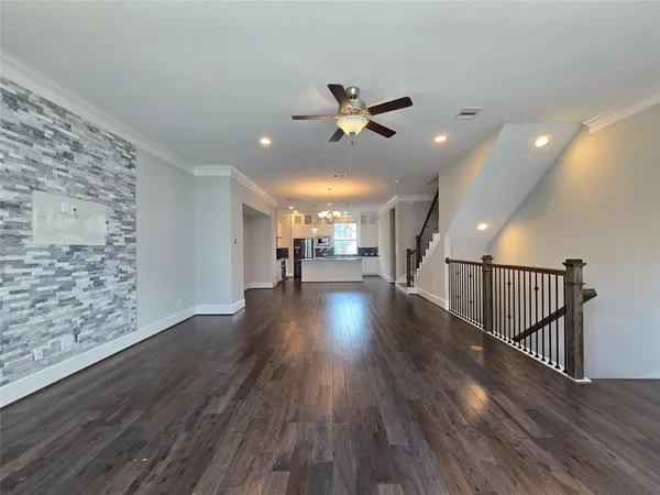 a view of a livingroom with wooden floor and a ceiling fan