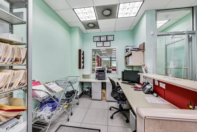 a view of a workspace with furniture and a window