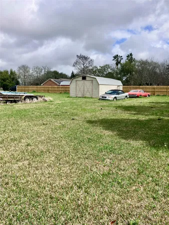 a view of a big house with a big yard and large trees
