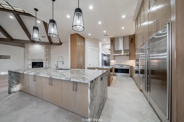 a large kitchen with stainless steel appliances kitchen island granite countertop a sink and cabinets