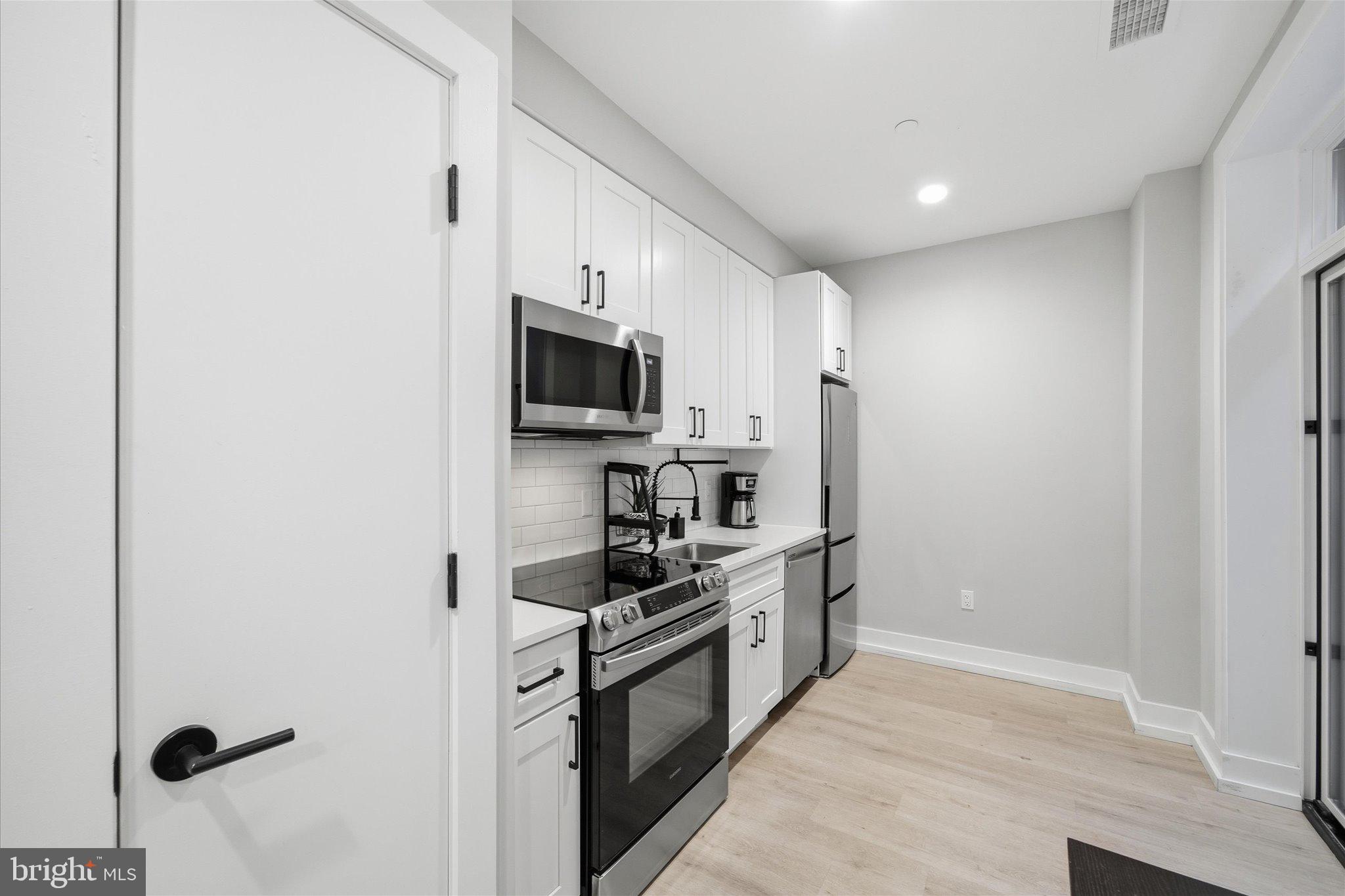 1016 17th Place Northeast, Unit 7 Washington, DC 20002 - Photo 9 of 28 a kitchen with stainless steel appliances a refrigerator a stove top oven a sink and dishwasher