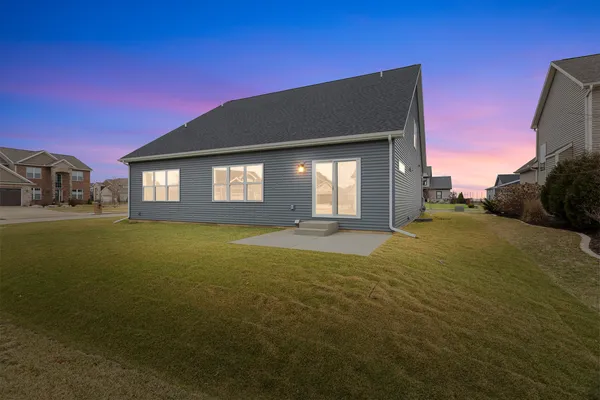 a view of a hallway with wooden floor and a bathroom