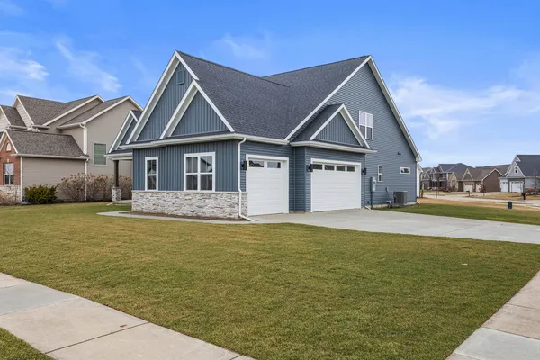 a kitchen with a sink dishwasher a stove and a microwave with wooden floor
