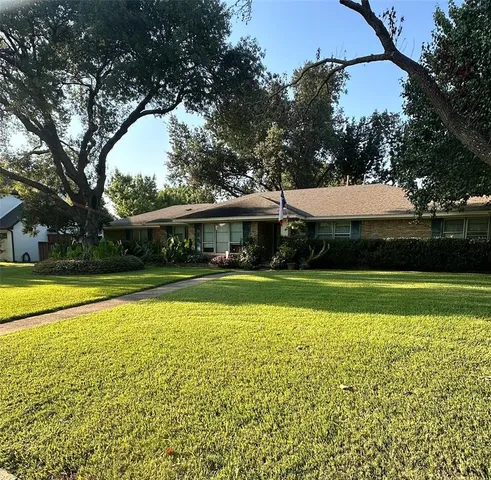 a view of swimming pool with lawn chairs and large trees