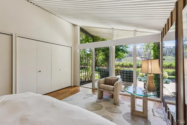 a tree in front of a house with wooden fence