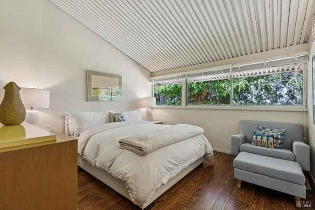a backyard of a house with potted plants and large tree