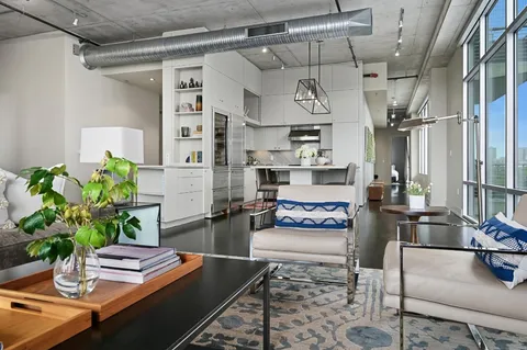 a kitchen with stainless steel appliances granite countertop a table chairs in it and wooden floor