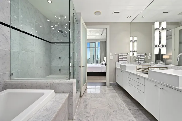 a bathroom with a double vanity sink large mirror and a bathtub