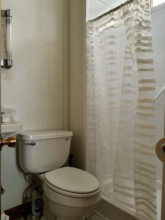 91 Smith Street Fall River, MA 02721 - Photo 11 of 23 a white toilet sitting next to a shower curtain