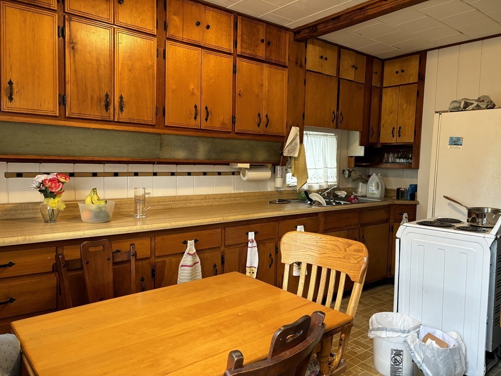 91 Smith Street Fall River, MA 02721 - Photo 7 of 23 a kitchen with a sink a stove and chairs