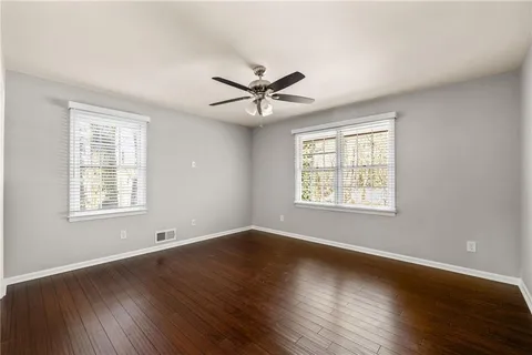 a view of a room with wooden floor and a ceiling fan