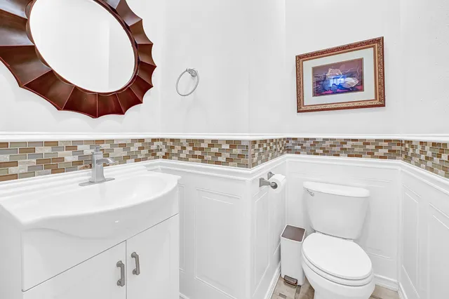 a bathroom with a toilet a sink and mirror