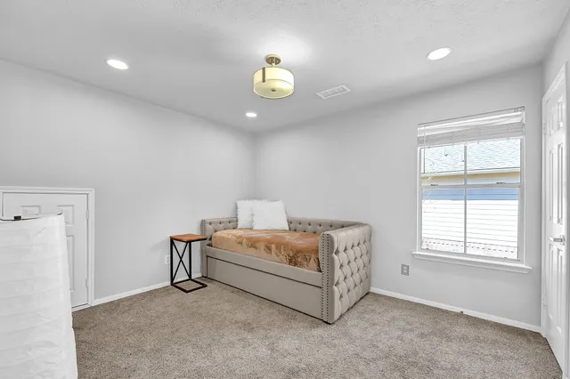 a spacious bedroom with a bed and a window