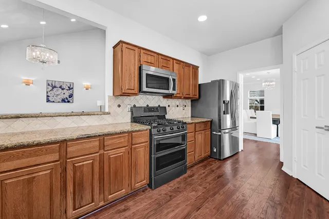 a kitchen with stainless steel appliances granite countertop a refrigerator stove and sink