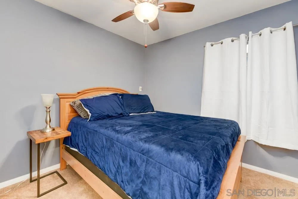 13008 Acton Avenue Poway, CA 92064 - Photo 15 of 28 a bedroom with a bed and a chandelier