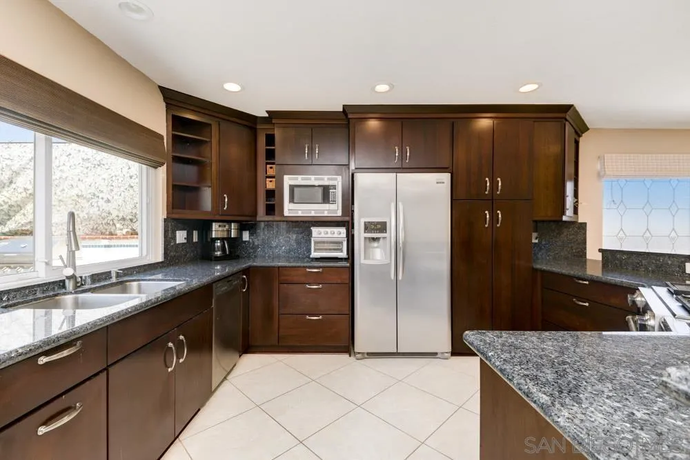 13008 Acton Avenue Poway, CA 92064 - Photo 5 of 28 a kitchen with stainless steel appliances granite countertop a refrigerator and a sink