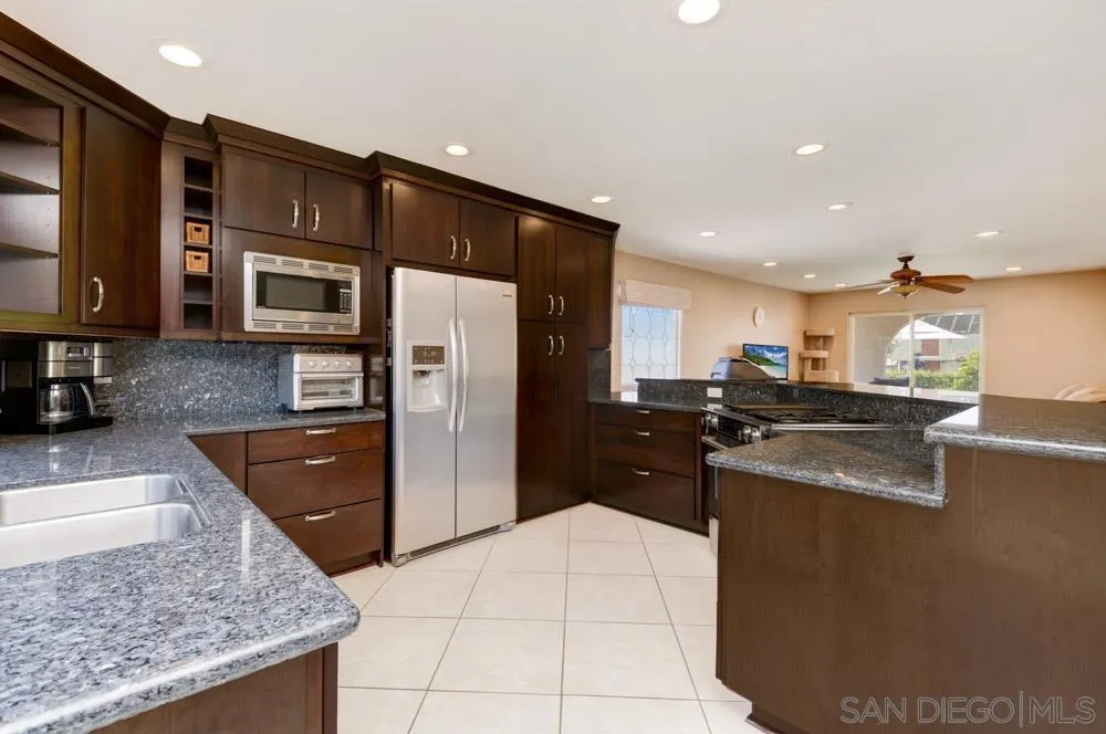 13008 Acton Avenue Poway, CA 92064 - Photo 6 of 28 a kitchen with stainless steel appliances granite countertop a refrigerator a stove and a sink
