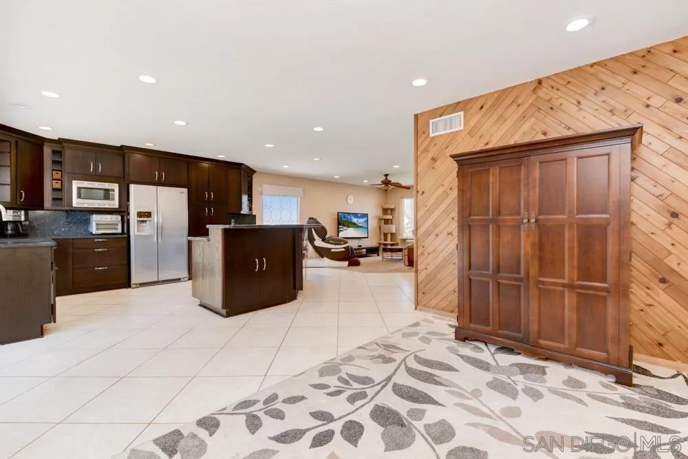13008 Acton Avenue Poway, CA 92064 - Photo 8 of 28 a kitchen with stainless steel appliances kitchen island granite countertop a refrigerator and a sink