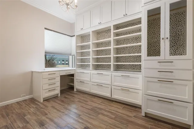 a view of an empty room with a window and a kitchen