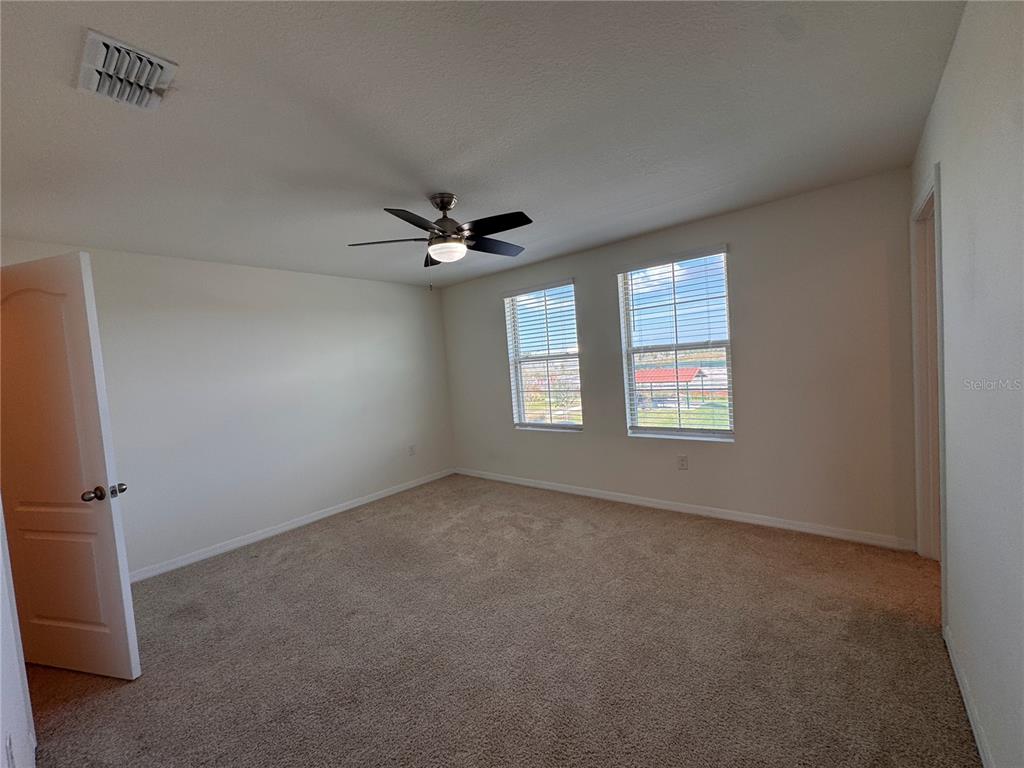 2095 King Ranch Street Kissimmee, FL 34744 - Photo 11 of 17 an empty room with windows and fan