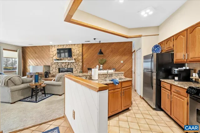 a open kitchen with stainless steel appliances kitchen island granite countertop a stove top oven a sink dishwasher and a refrigerator