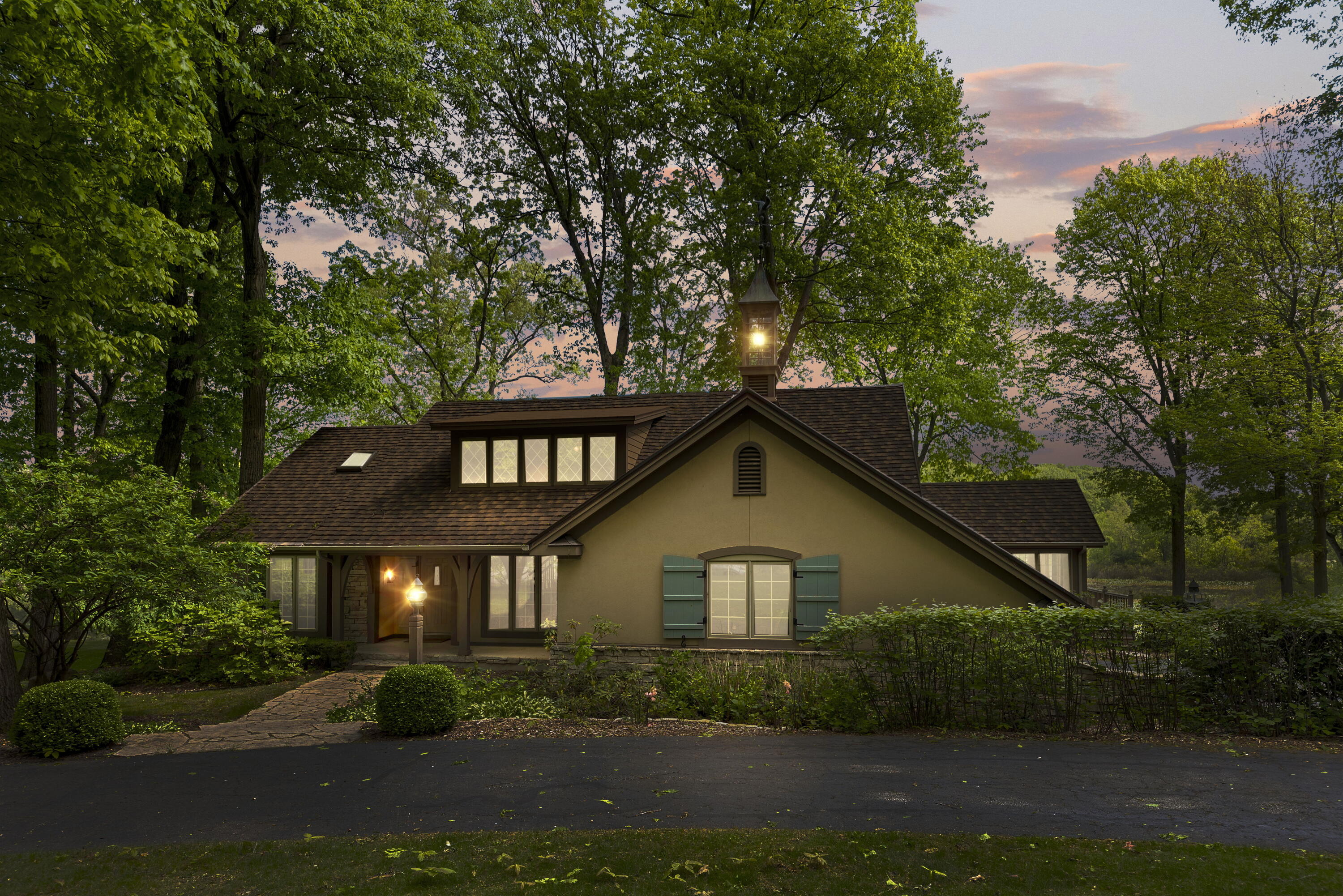 a front view of a house with a yard and green space