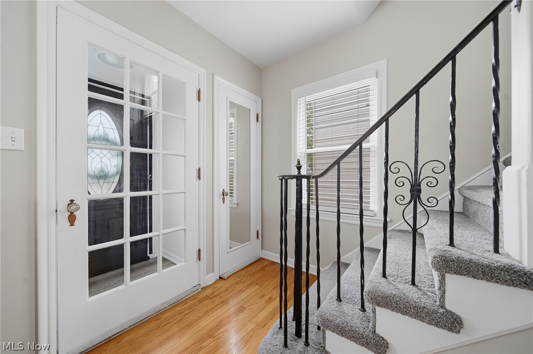2231 Brockway Road University Heights, OH 44118 - Photo 3 of 46 Entryway featuring hardwood flooring, white French doors with glass panes, and a wrought iron staircase railing with decorative elements
