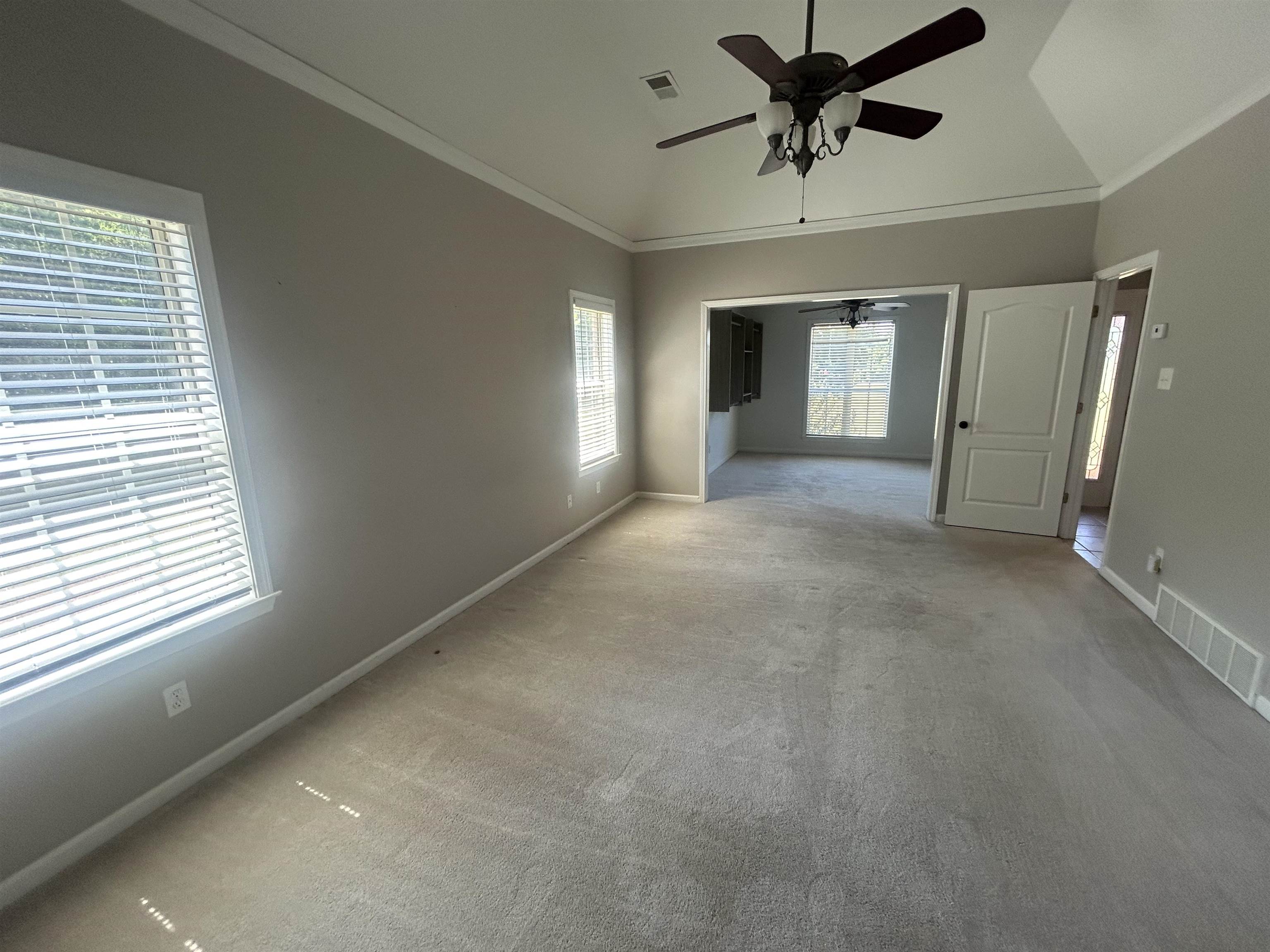 9958 Idaville Road Atoka, TN 38004 - Photo 13 of 20 Carpeted spare room featuring lofted ceiling, crown molding, and a ceiling fan