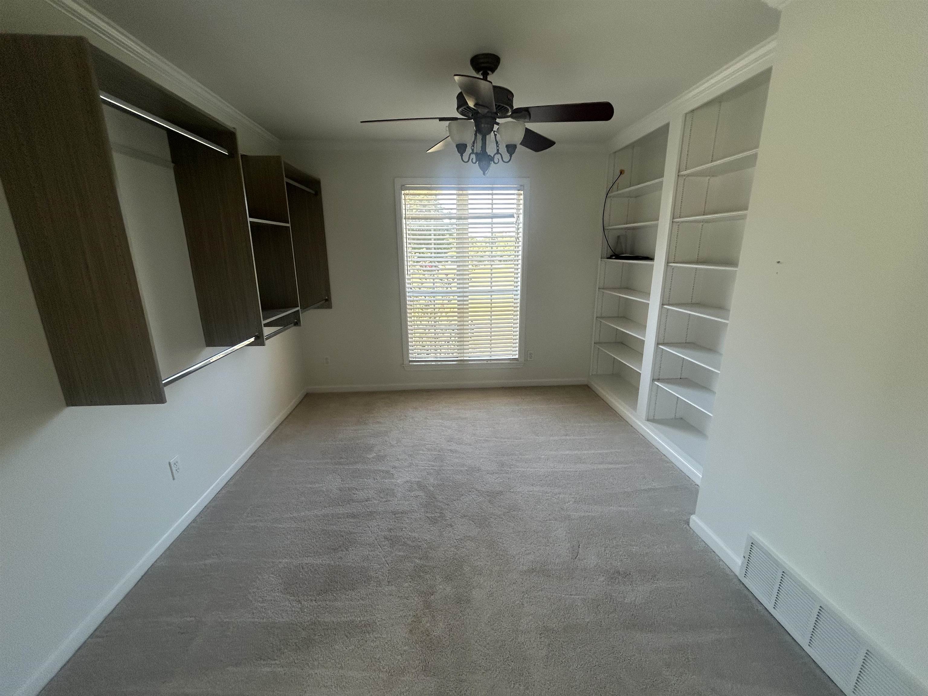 9958 Idaville Road Atoka, TN 38004 - Photo 14 of 20 Unfurnished dining area with light carpet, crown molding, built in features, and ceiling fan