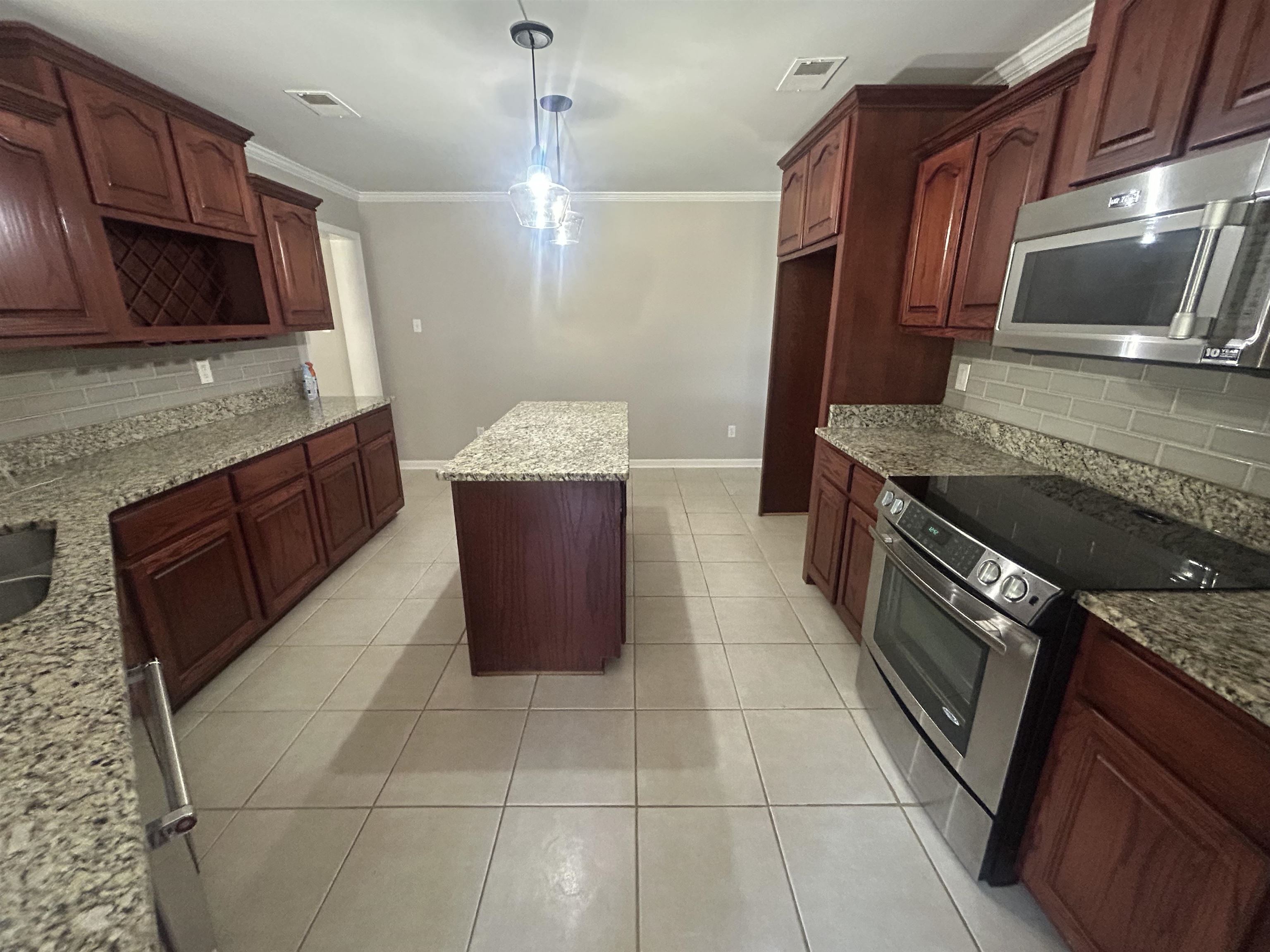 9958 Idaville Road Atoka, TN 38004 - Photo 4 of 20 Kitchen featuring backsplash, stainless steel appliances, light stone counters, light tile patterned flooring, and hanging light fixtures