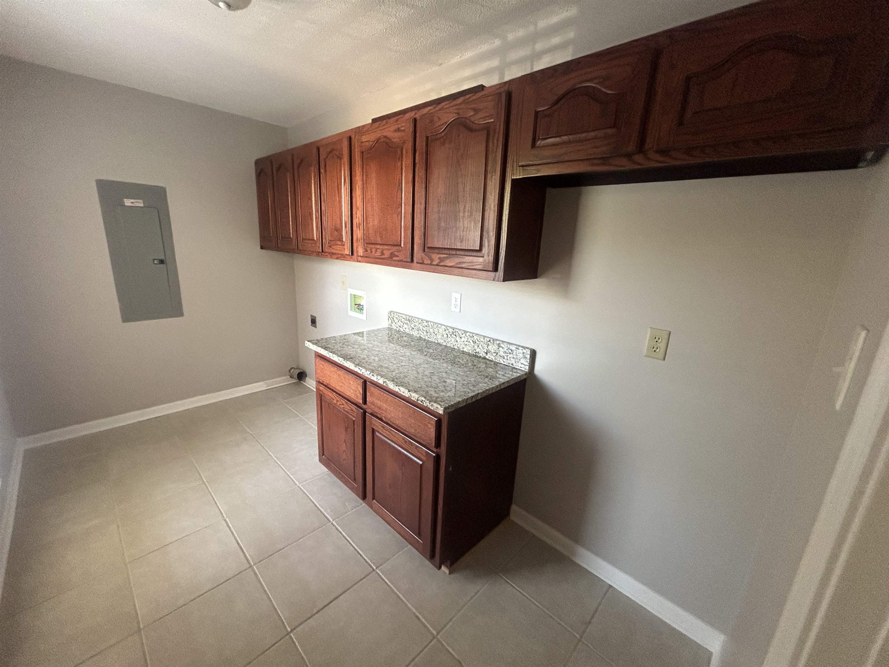 9958 Idaville Road Atoka, TN 38004 - Photo 10 of 20 Laundry room with cabinet space, electric panel, light tile patterned floors, washer hookup, and electric dryer hookup