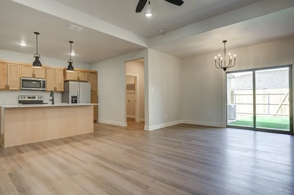 a view of kitchen with granite countertop cabinets and refrigerator